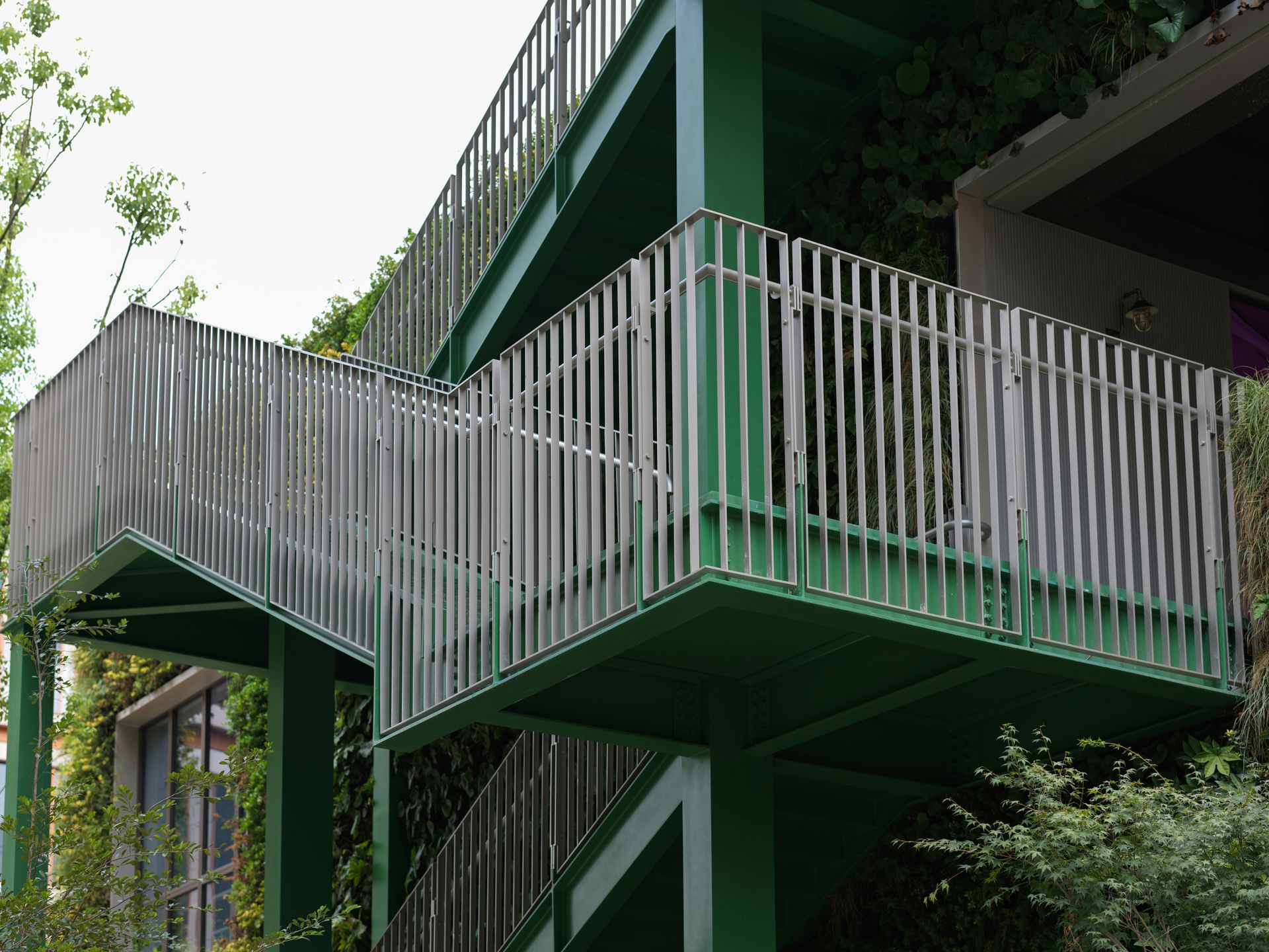 A green building with a white balcony and balconies